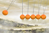 Newtons cradle above city in mountains