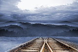 Train tracks leading to misty mountains