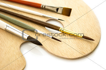 Art color brushes on woode palette isolated