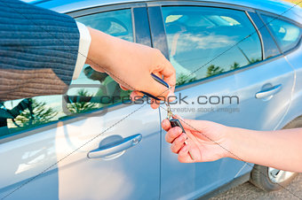 handing the keys to a new car customer