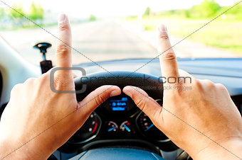 male hands on the steering wheel with protruding fingers