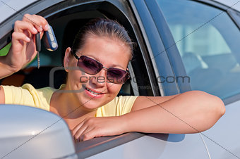 woman showing the key of her new car