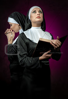 Two attractive young nuns with rosary beads and bible