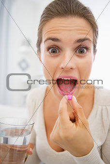 Young woman eating pills