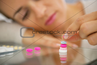 Closeup on young woman playing with pills