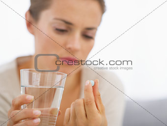 Closeup on young housewife eating pills
