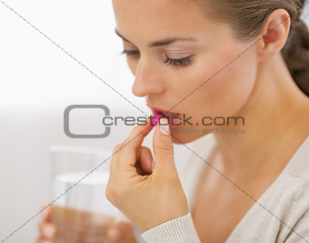 Young woman eating pill