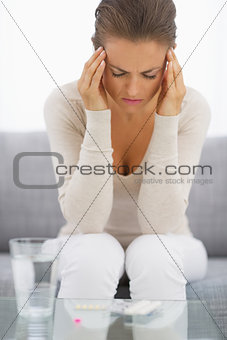 Portrait of stressed young housewife in living room