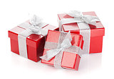 Three red gift boxes with silver ribbon and bow