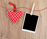 Blank instant photo and red heart hanging on the clothesline