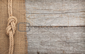 Ship rope on wood and burlap texture background