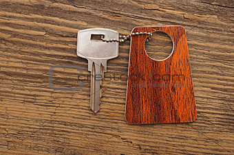 silver key with blank tag wooden background. space for your text
