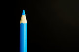 Blue pencil crayon on a black background