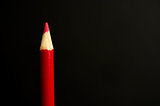 Red pencil crayon on a black background