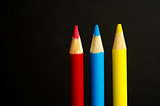 Primary coloured pencil crayons on a black background