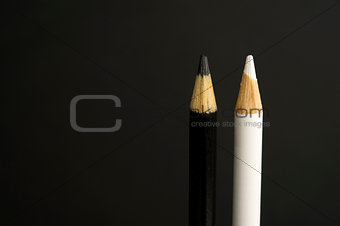 black and white coloured pencil crayons on a black background