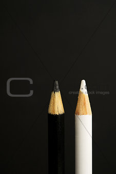black and white coloured pencil crayons on a black background