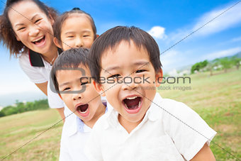 Asian smiling family playing on meadow and sunny day