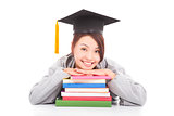 asian smiling  student leaning on stacked books