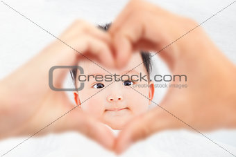  cute and smiling infant  with parents love hands 