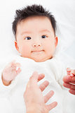  cute and smiling infant  with mother hands 