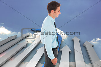 Composite image of happy businessman standing with hand in pocket