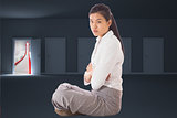 Composite image of businesswoman sitting cross legged with arms crossed