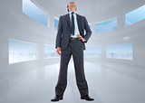 Composite image of happy businessman with hand on hip
