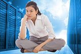 Composite image of grumpy businesswoman sitting cross legged