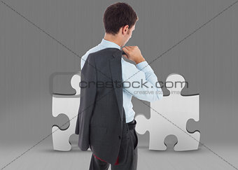 Composite image of businessman holding his jacket