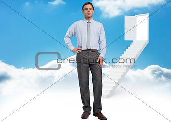 Composite image of serious businessman with hand on hip