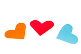 Three paper colored heart shapes on a white background