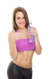 Fit young woman holding bottle of water showing thumb up