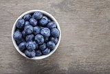 fresh blueberries in white bowl on wood table