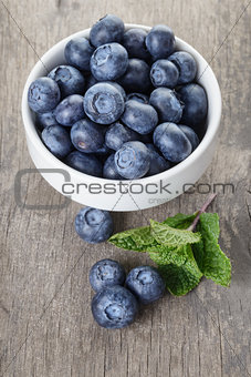 fresh blueberries in white bowl on wood table