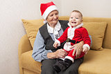 Baby boy in Santa costume with his great grandmother