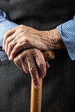Closeup of senior woman's hands on wooden walking stick