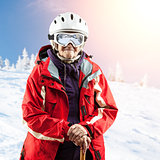 Senior woman in ski jacket and goggles outdoors. With path.