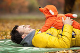 Young father and his little son in fox costume having fun in autumn park