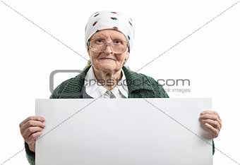 Smiling elderly lady holding blank sheet in hands over white