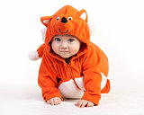 Baby boy in fox costume looking at camera over white