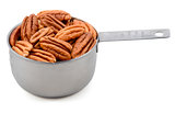 Whole pecan nuts in a metal cup measure