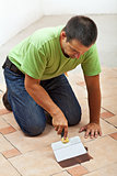 Construction worker testing the joint color on ceramic tiles flo