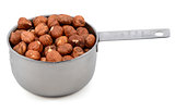 Whole hazelnuts in a metal cup measure