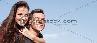 young male giving his girlfriend piggyback ride