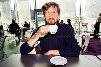 Young man drinking coffee in a cafe