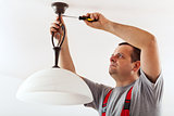 Electrician mounting ceiling lamp