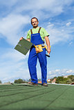 Worker installing bitumen roof shingles