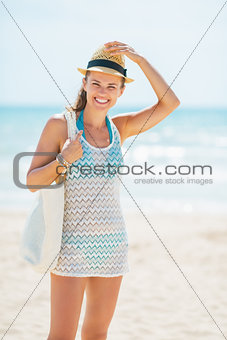 Portrait of smiling young woman in hat on beach