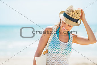 Smiling young woman in hat on beach